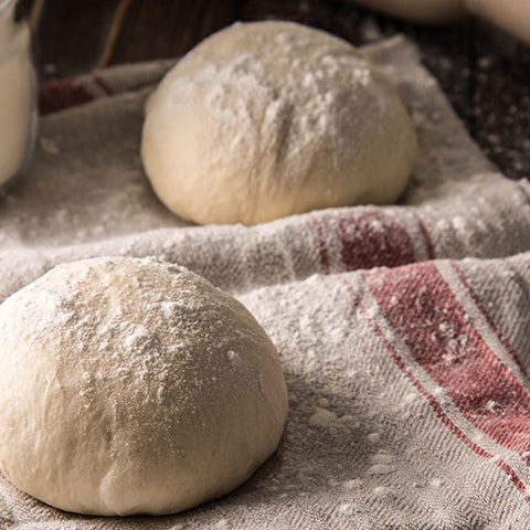 Image of Deegschraper van DeliVita verdeel je pizzadeeg en houd je je werkblad schoon. Handige tool voor in de keuken gemaakt van roestvrijstaal (RVS) en olijfhout. Deegbollen op een theedoek, klaar om in de pizzaoven te gaan.