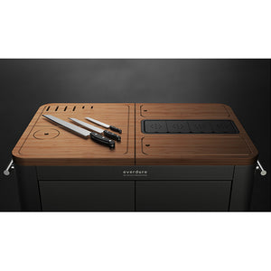 De Pizzaoven Shop - Everdure - Prep kitchen. Dit mat-zwarte rijbare keukenblok, voorzien van vele gemakken, is de perfecte toevoeging aan uw buitenkeuken. In het houten keukenblad zitten handige opbergluikjes, messenblok en andere handigheidjes verwerkt.
