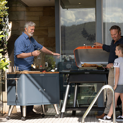 Image of De Pizzaoven Shop - Everdure - Prep kitchen. Dit mat-zwarte rijbare keukenblok, voorzien van vele gemakken, is de perfecte toevoeging aan uw buitenkeuken. In het houten keukenblad zitten handige opbergluikjes, messenblok en andere handigheidjes verwerkt.